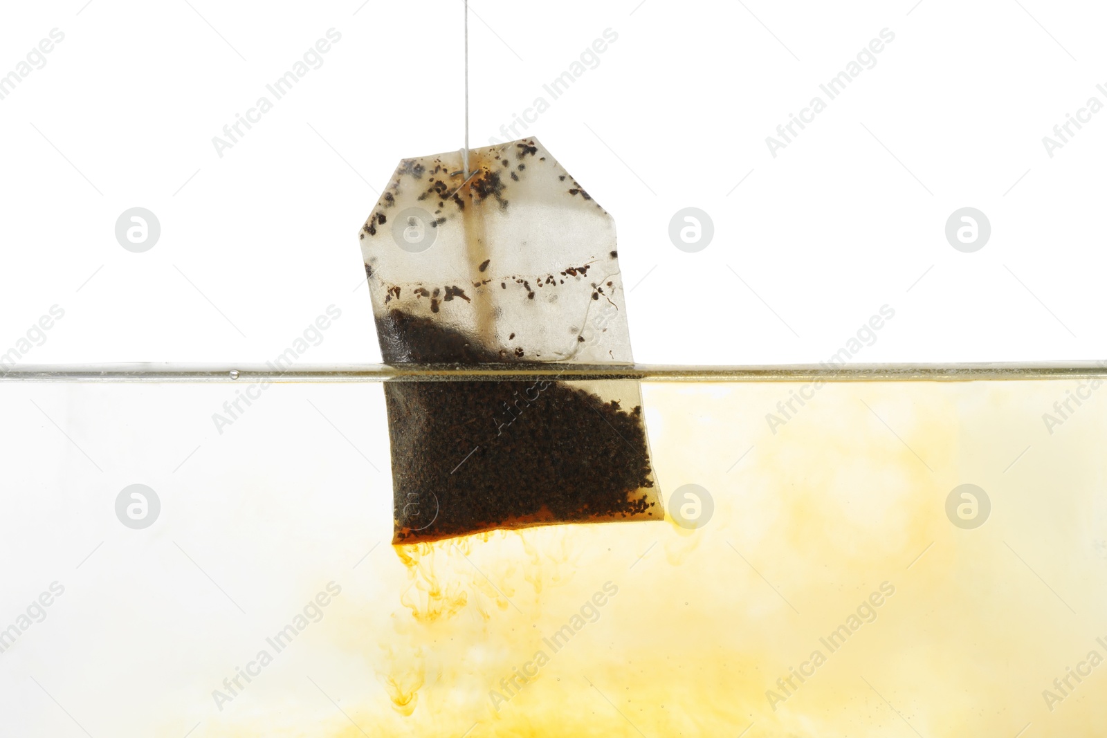 Photo of Putting tea bag into glass cup on white background, closeup