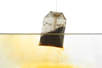 Photo of Putting tea bag into glass cup on white background, closeup