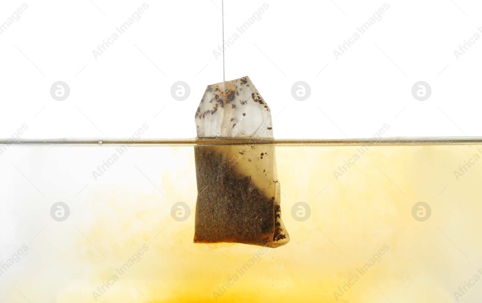 Photo of Putting tea bag into glass cup on white background, closeup