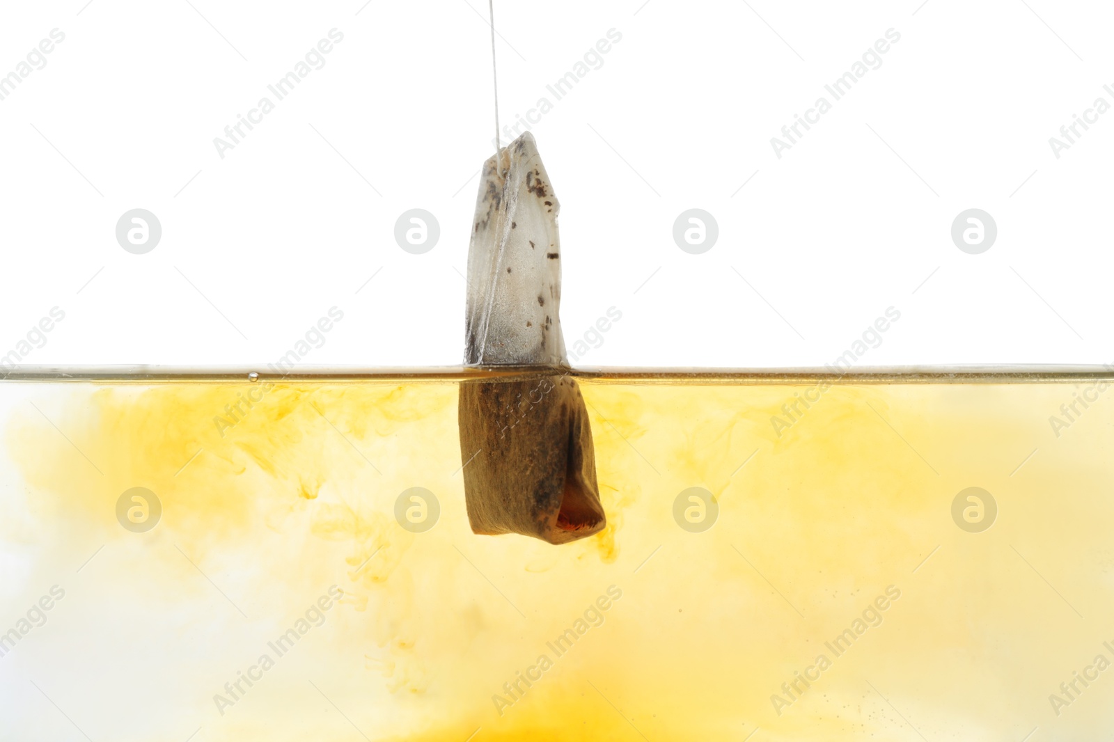 Photo of Putting tea bag into glass cup on white background, closeup