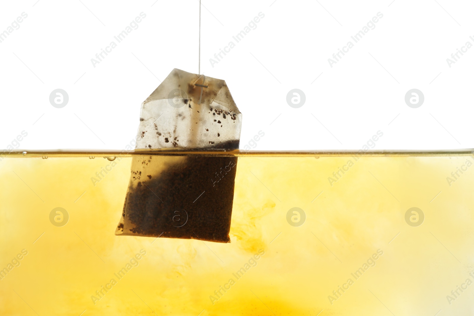 Photo of Putting tea bag into glass cup on white background, closeup