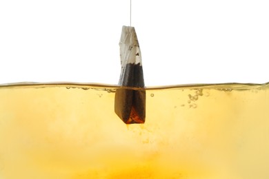 Photo of Putting tea bag into glass cup on white background, closeup