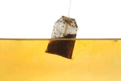 Photo of Putting tea bag into glass cup on white background, closeup