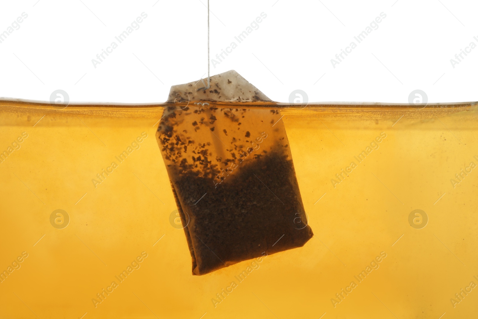 Photo of Putting tea bag into glass cup on white background, closeup