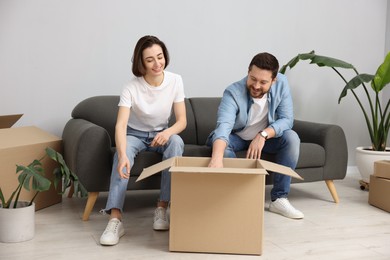 Photo of Moving day. Happy couple unpacking their belongings in new home