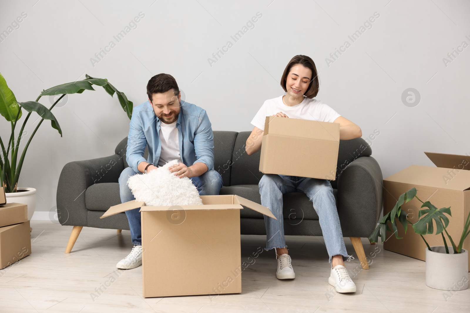 Photo of Moving day. Happy couple unpacking their belongings in new home