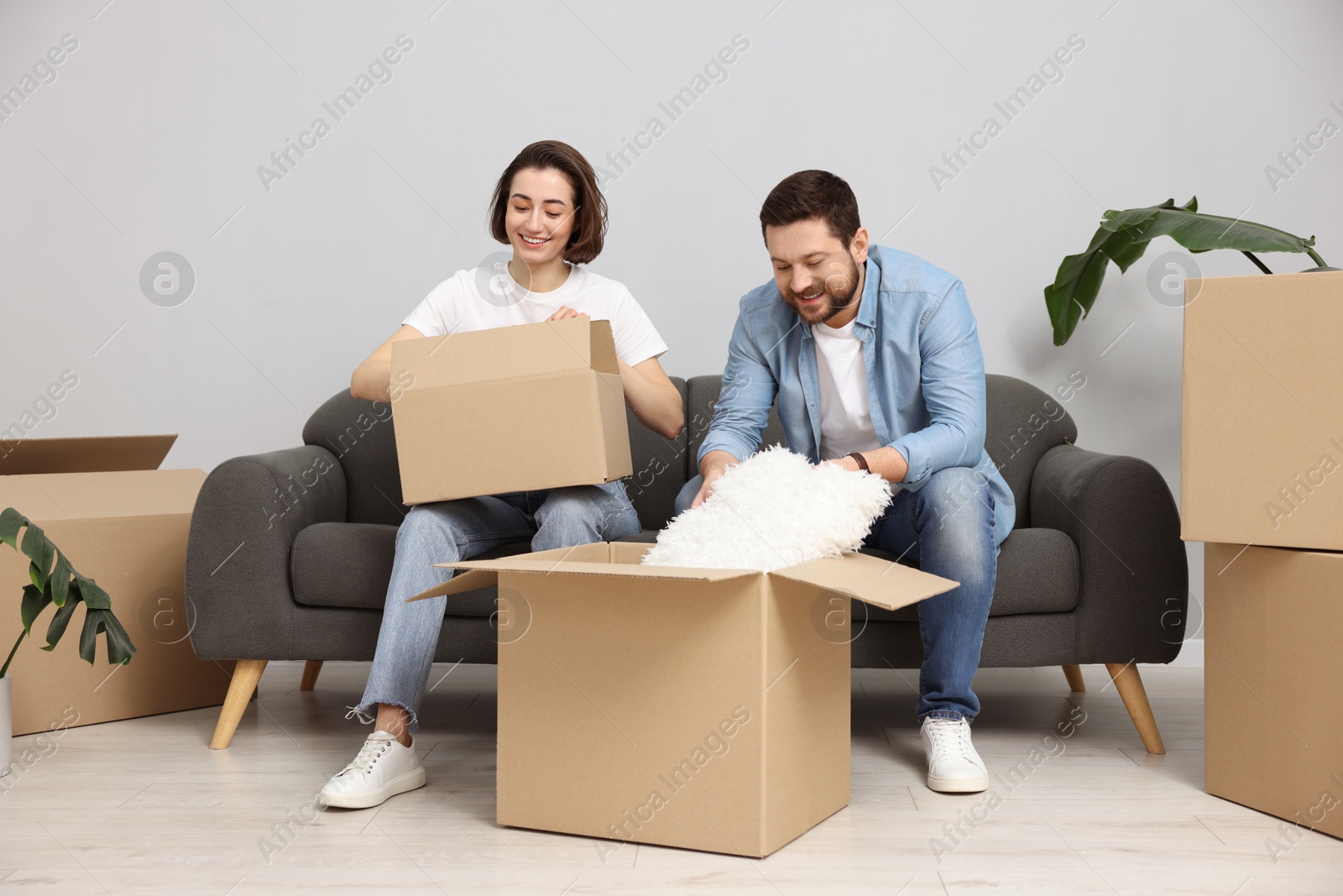 Photo of Moving day. Happy couple unpacking their belongings in new home