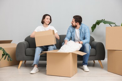 Photo of Moving day. Happy couple unpacking their belongings in new home