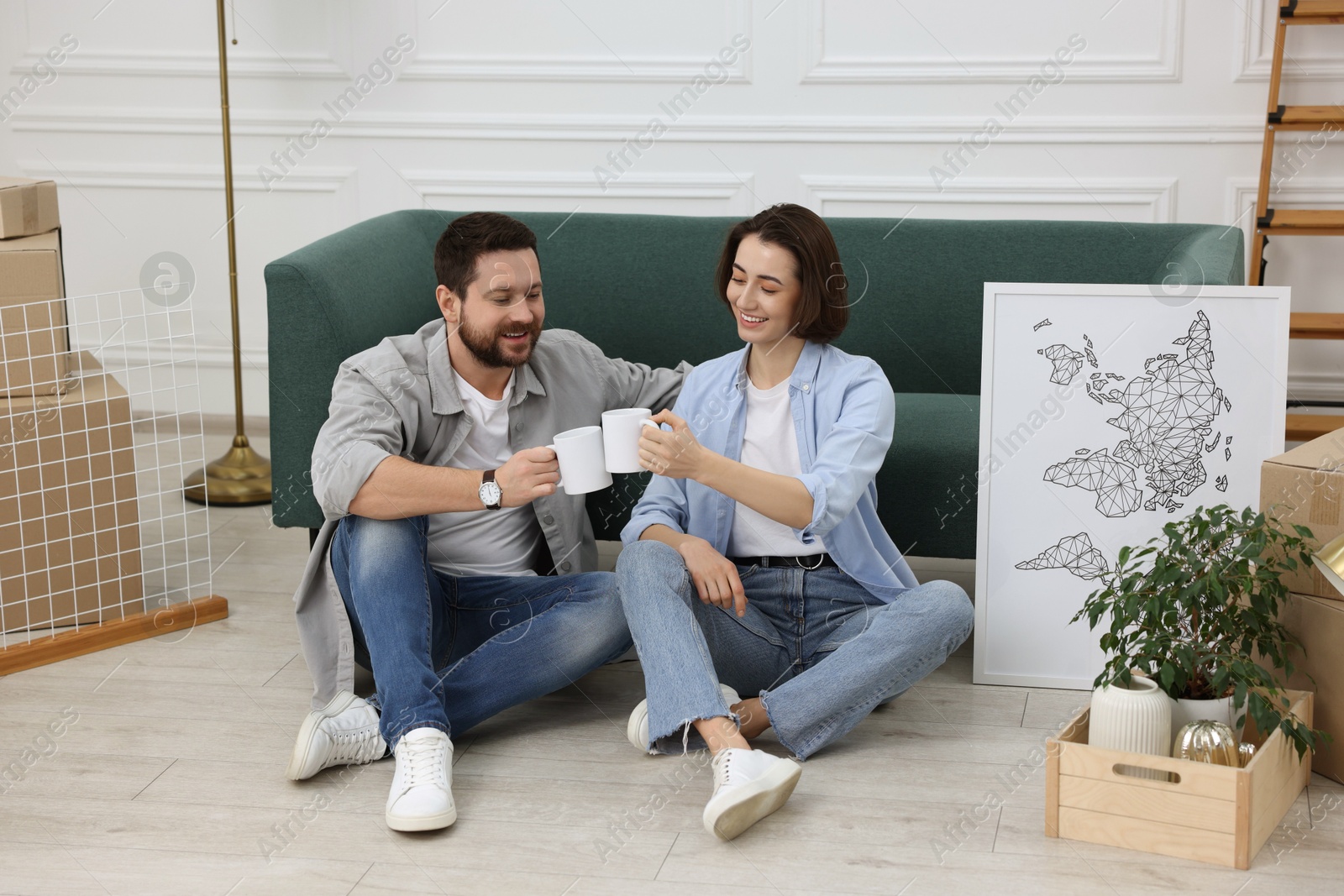 Photo of Moving day. Happy couple with coffee in their new home