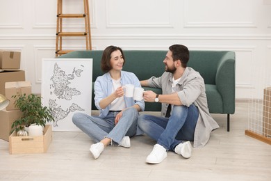 Photo of Moving day. Happy couple with coffee in their new home