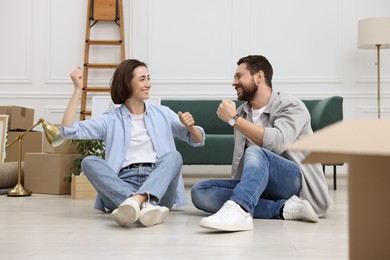 Photo of Moving day. Happy couple having fun in their new home