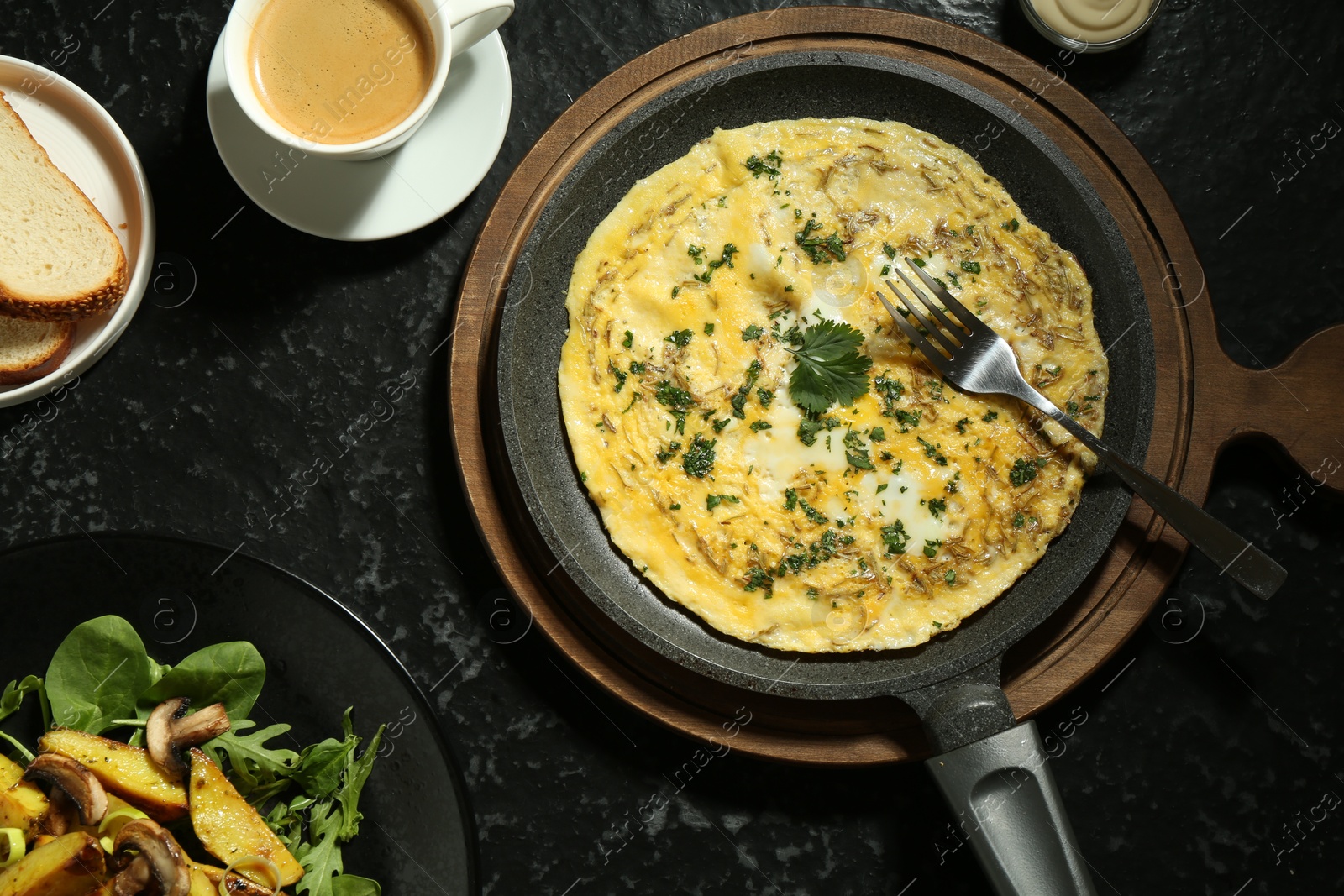 Photo of Tasty brunch. Delicious omelette, fried potatoes and coffee served on black textured table, flat lay