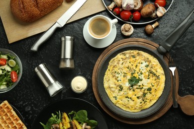 Photo of Tasty food served for brunch on black table, flat lay