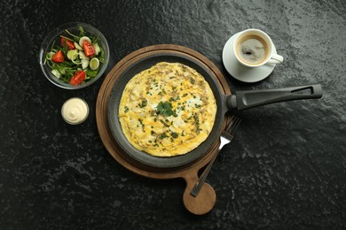 Photo of Tasty brunch. Delicious omelette, salad and coffee served on black textured table, flat lay