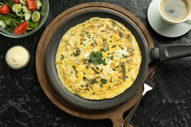 Photo of Tasty brunch. Delicious omelette, salad and coffee served on black textured table, flat lay