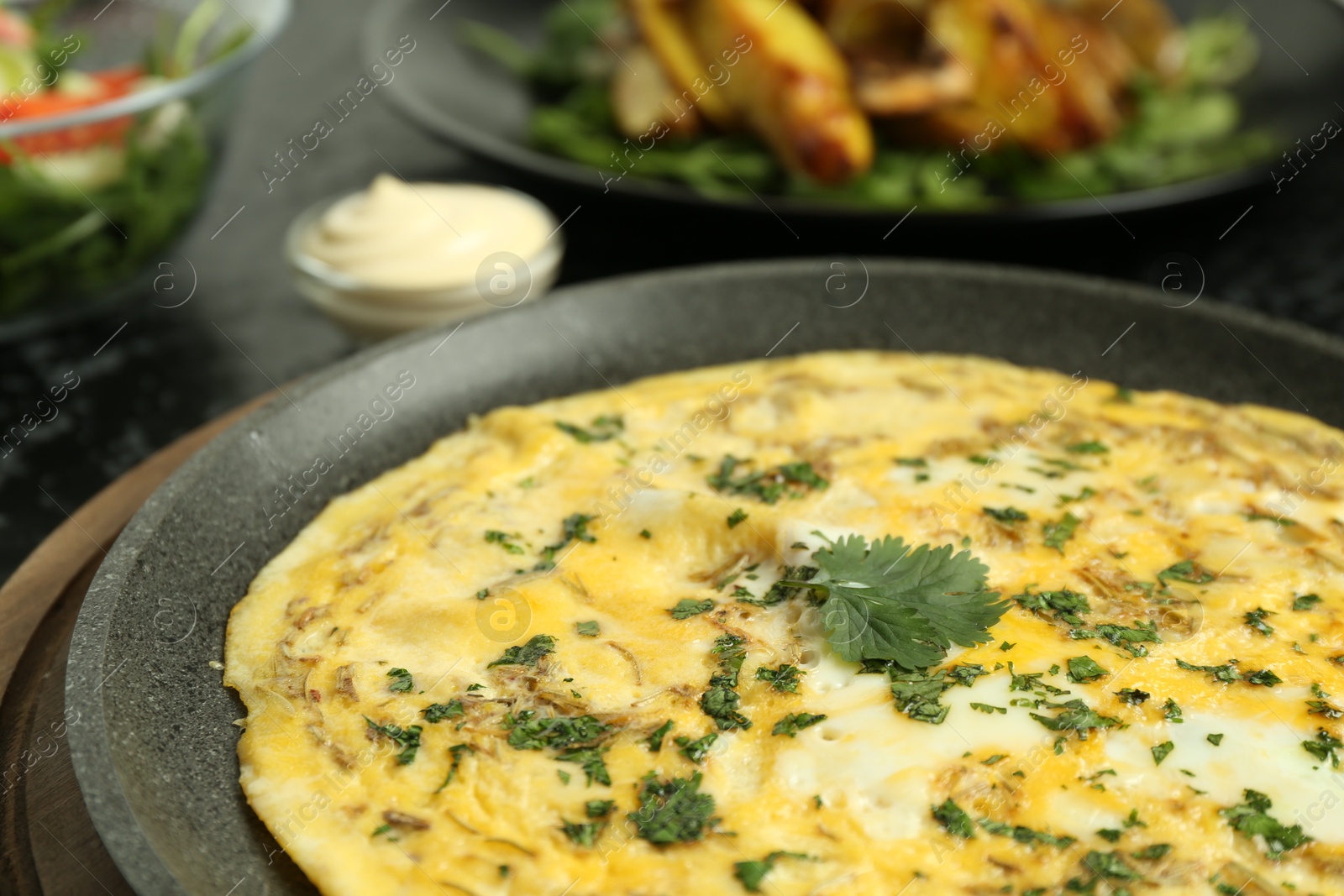 Photo of Tasty brunch. Delicious omelette with parsley served on table, closeup