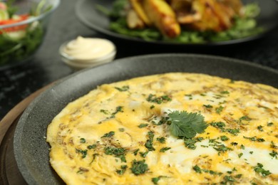 Photo of Tasty brunch. Delicious omelette with parsley served on table, closeup