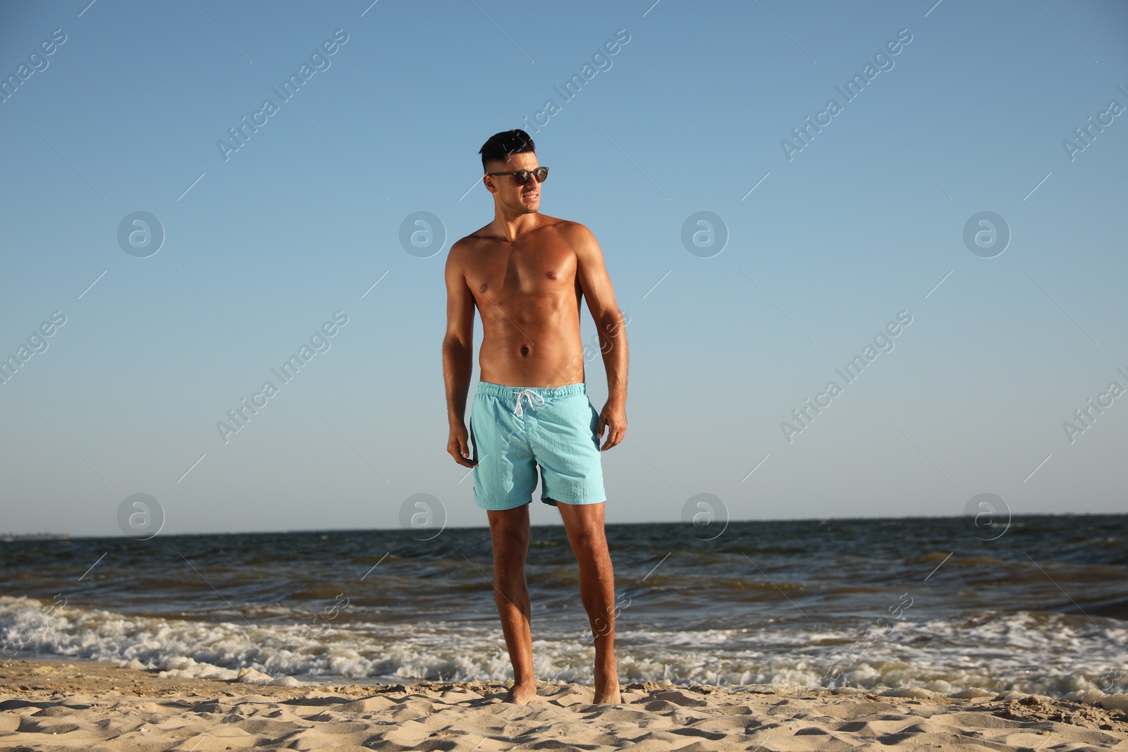 Photo of Handsome man with attractive body on beach