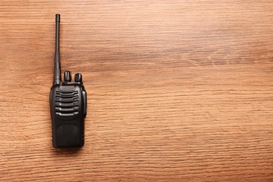 Photo of One walkie talkie on wooden table, top view. Space for text