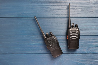 Photo of Walkie talkies on blue wooden table, top view. Space for text