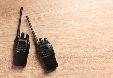 Photo of Walkie talkies on wooden table, top view. Space for text