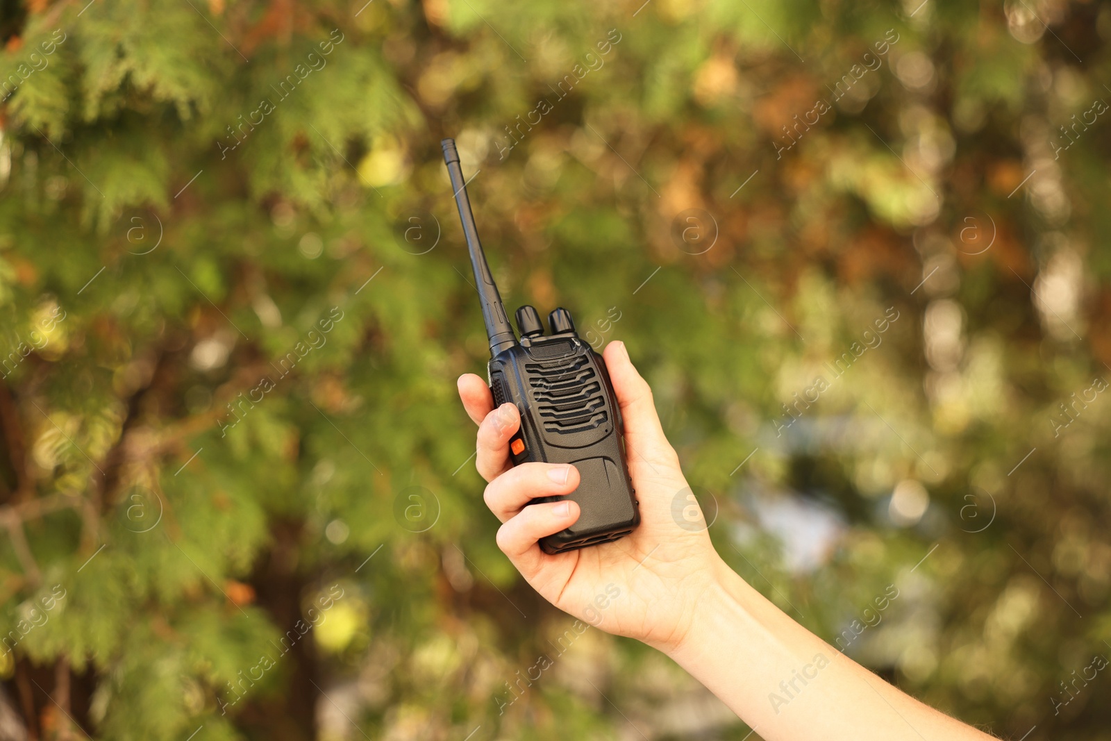 Photo of Woman with walkie talkie in park, closeup