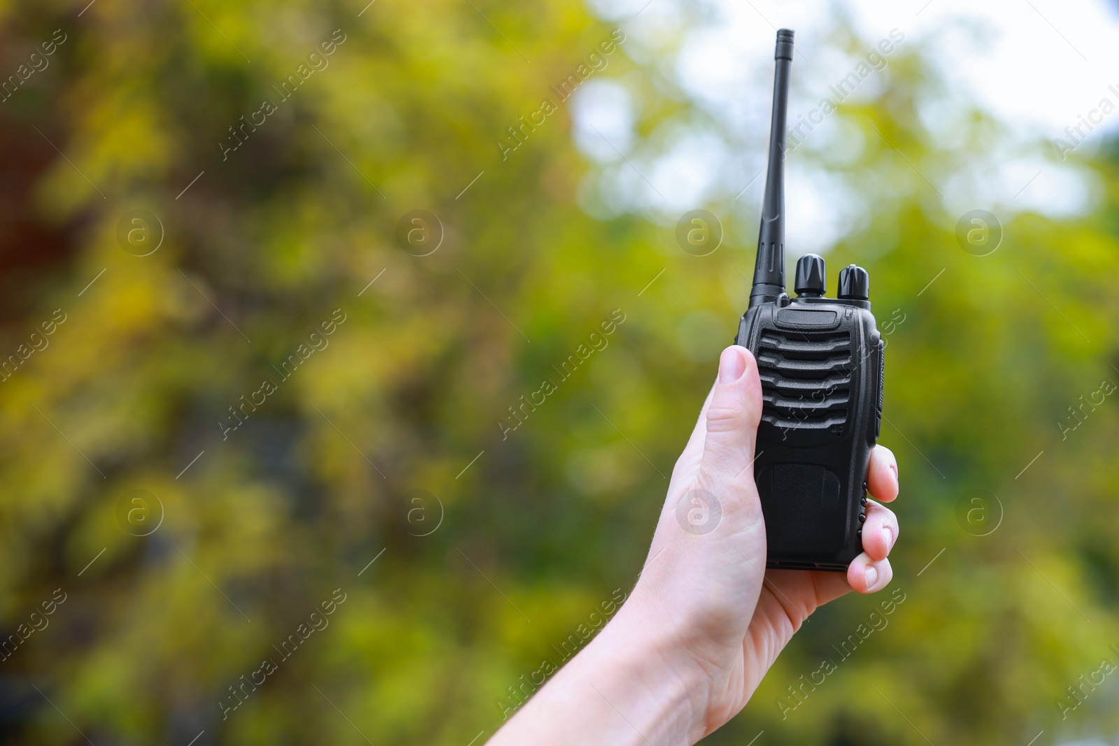 Photo of Woman with walkie talkie outdoors, closeup. Space for text