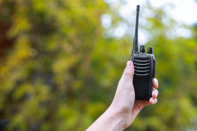 Photo of Woman with walkie talkie outdoors, closeup. Space for text