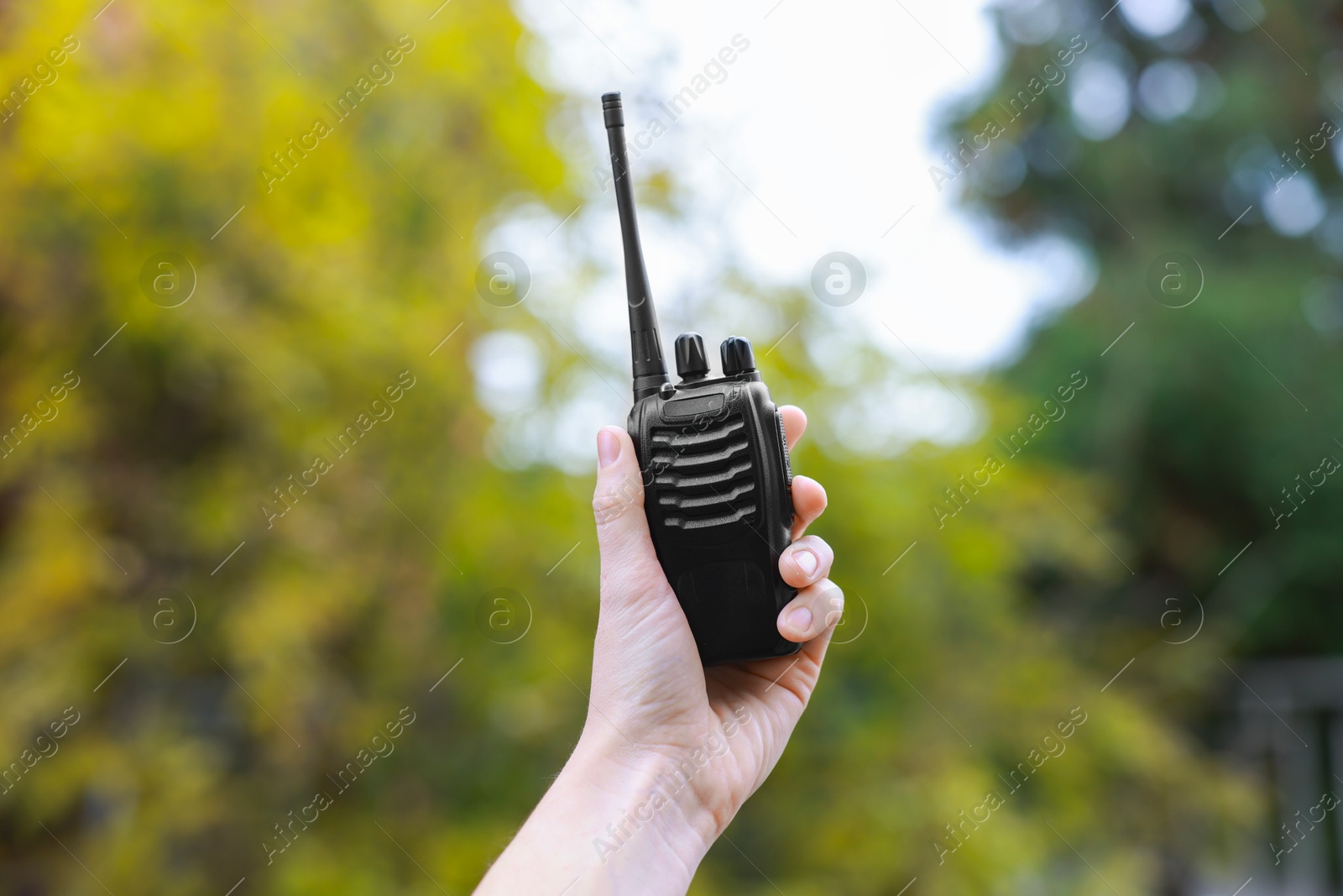 Photo of Woman with walkie talkie in park, closeup