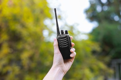 Photo of Woman with walkie talkie in park, closeup