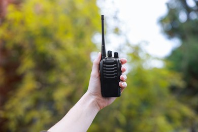 Photo of Woman with walkie talkie in park, closeup