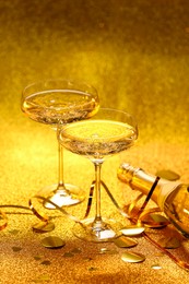 Photo of Champagne, confetti and streamers on golden background