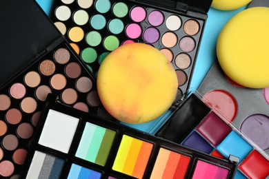 Photo of Bright face paints and sponges on light blue background, flat lay