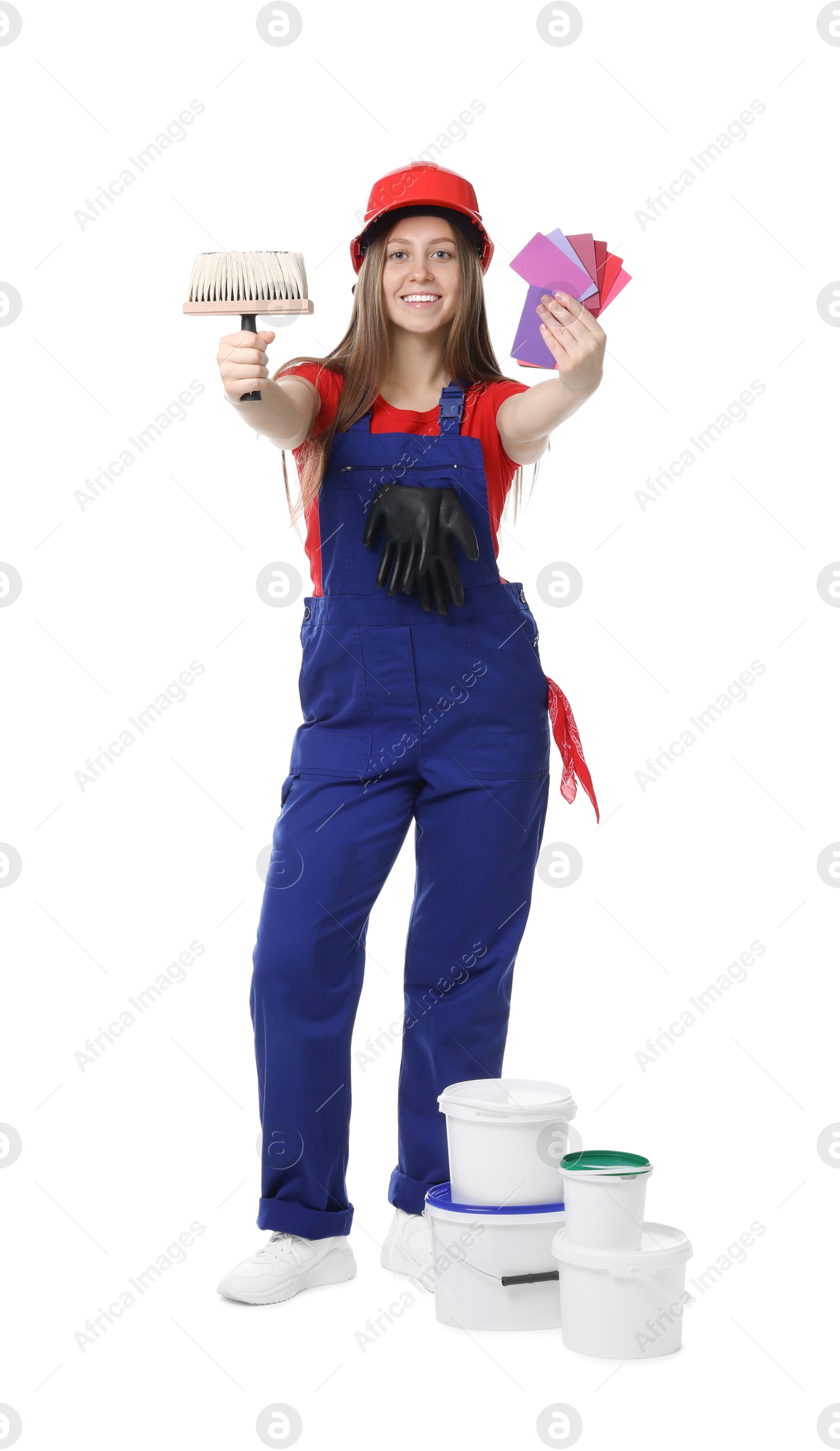 Photo of Professional painter with brush, color samples and buckets of paint on white background