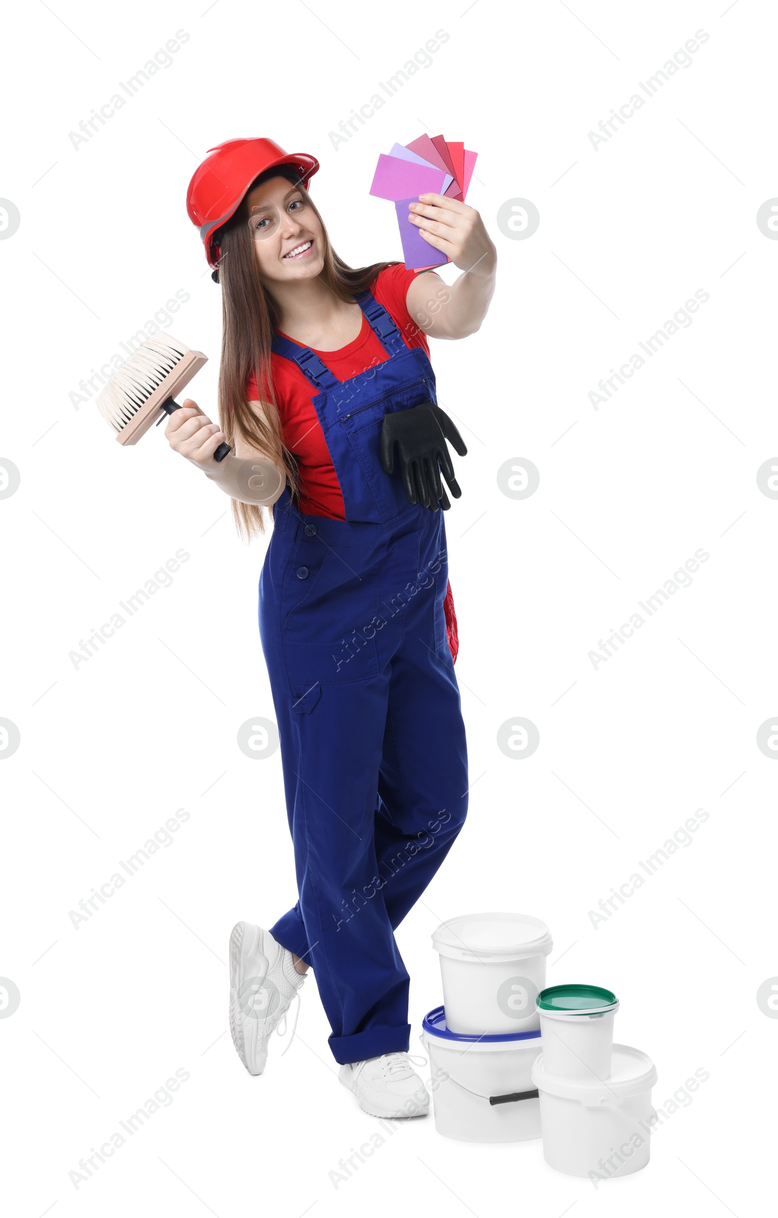 Photo of Professional painter with brush, color samples and buckets of paint on white background