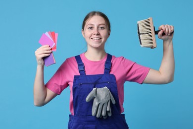 Photo of Professional painter with brush and color samples on light blue background