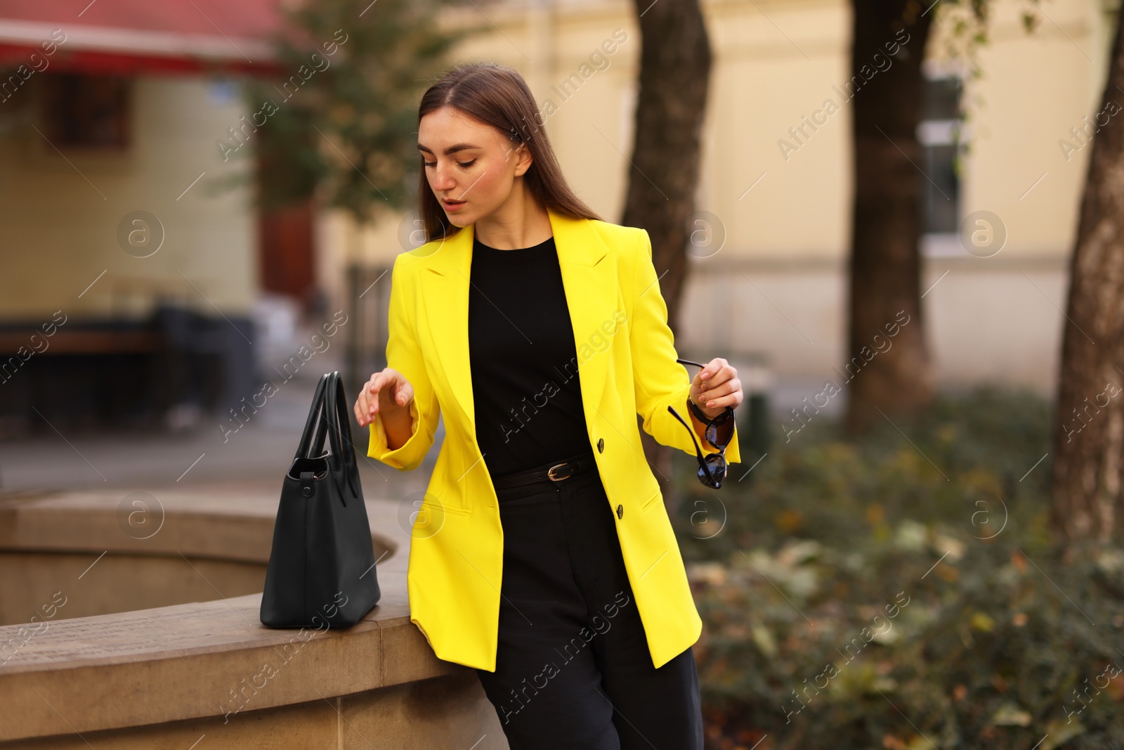 Photo of Beautiful businesswoman in stylish suit on city street