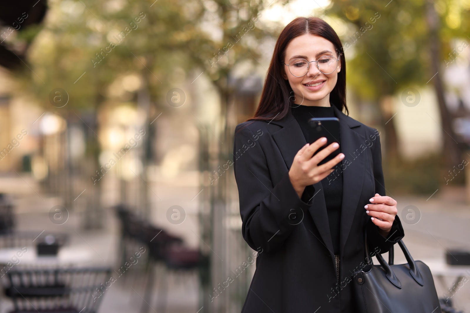 Photo of Smiling businesswoman in stylish suit with smartphone outdoors. Space for text