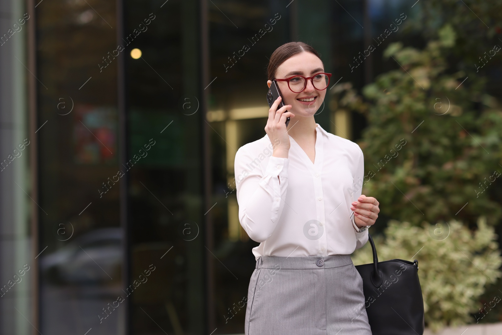 Photo of Woman in stylish outfit talking on phone outdoors. Space for text