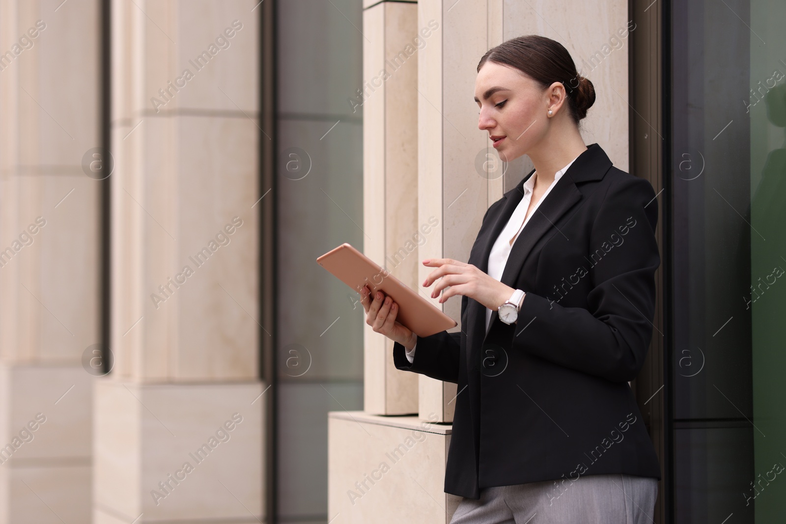 Photo of Woman in stylish formal suit with tablet outdoors. Space for text