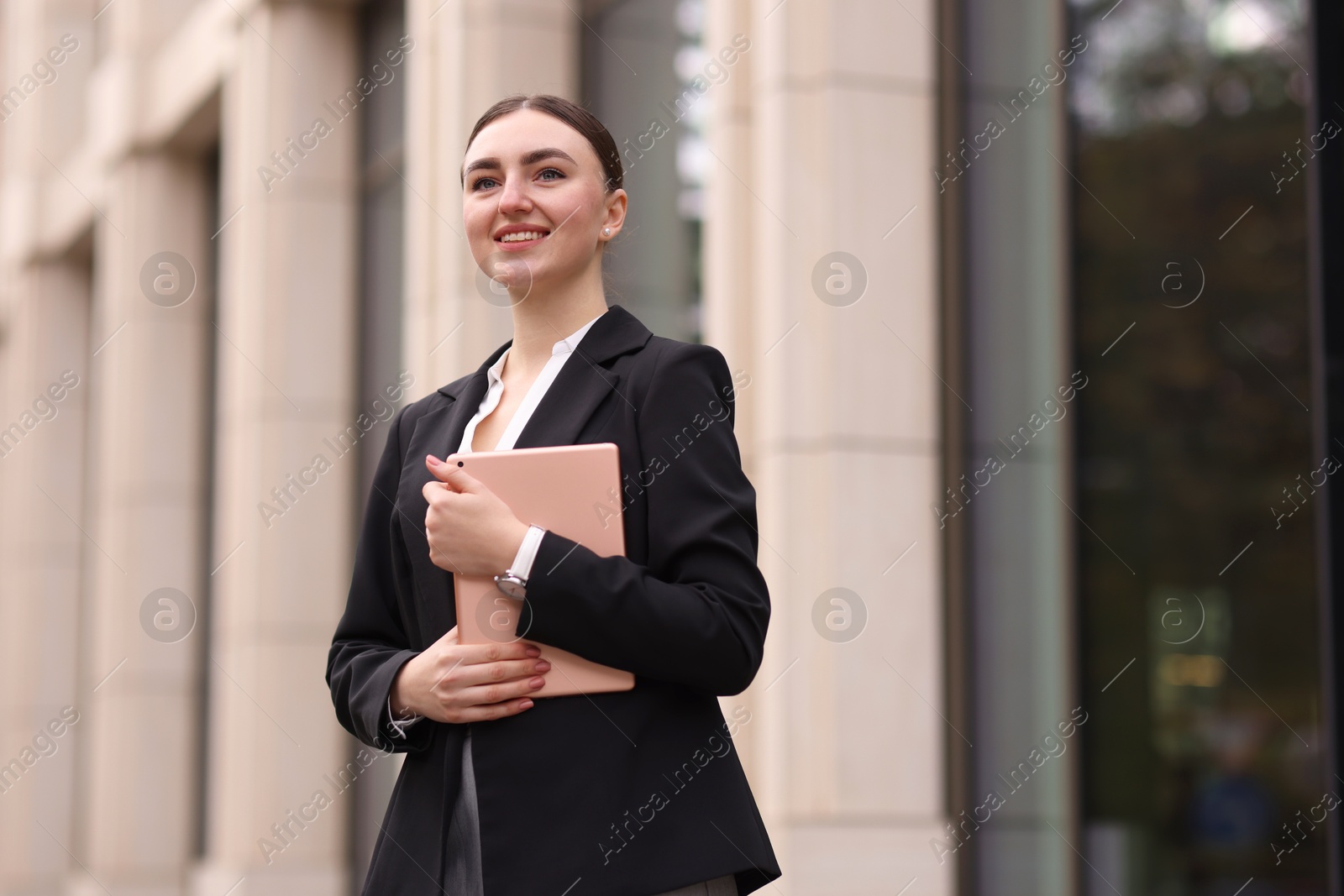 Photo of Woman in stylish formal suit with tablet outdoors