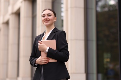 Photo of Woman in stylish formal suit with tablet outdoors