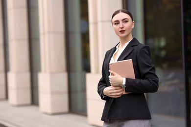 Photo of Woman in stylish formal suit with tablet outdoors. Space for text