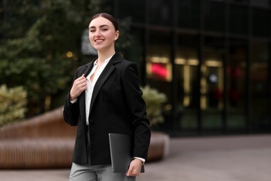 Photo of Woman in stylish formal suit with laptop outdoors. Space for text