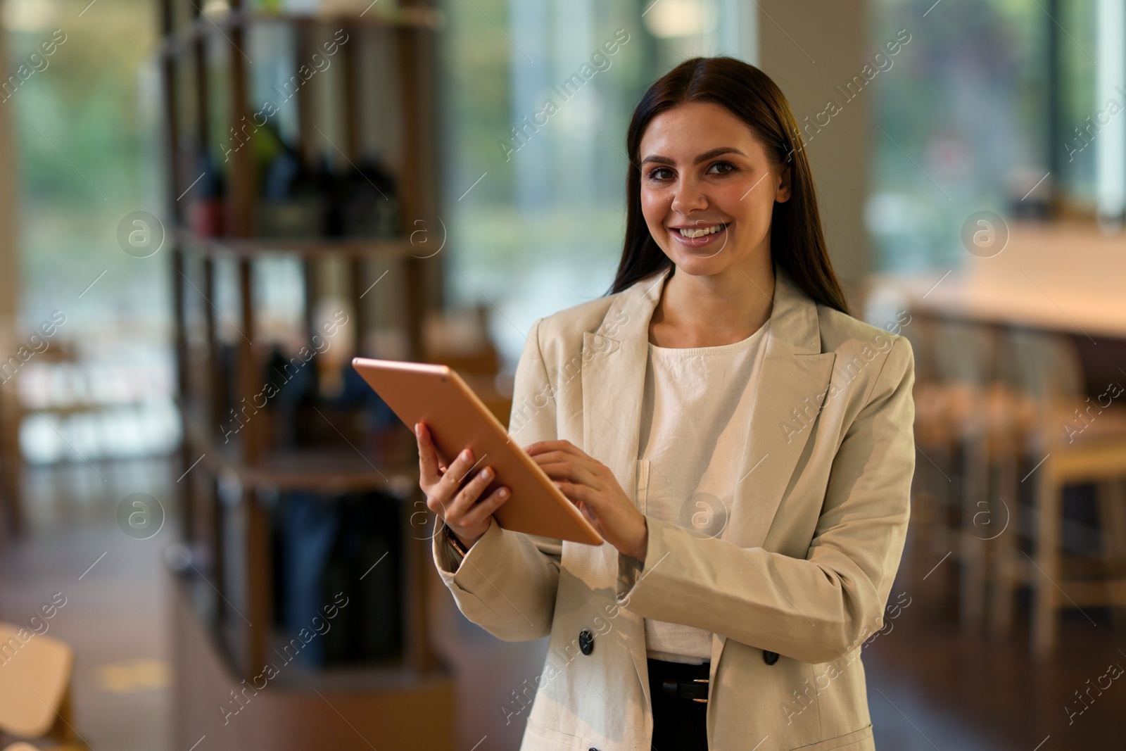 Photo of Woman in stylish formal suit with tablet indoors. Space for text