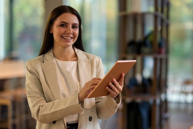 Photo of Woman in stylish formal suit with tablet indoors