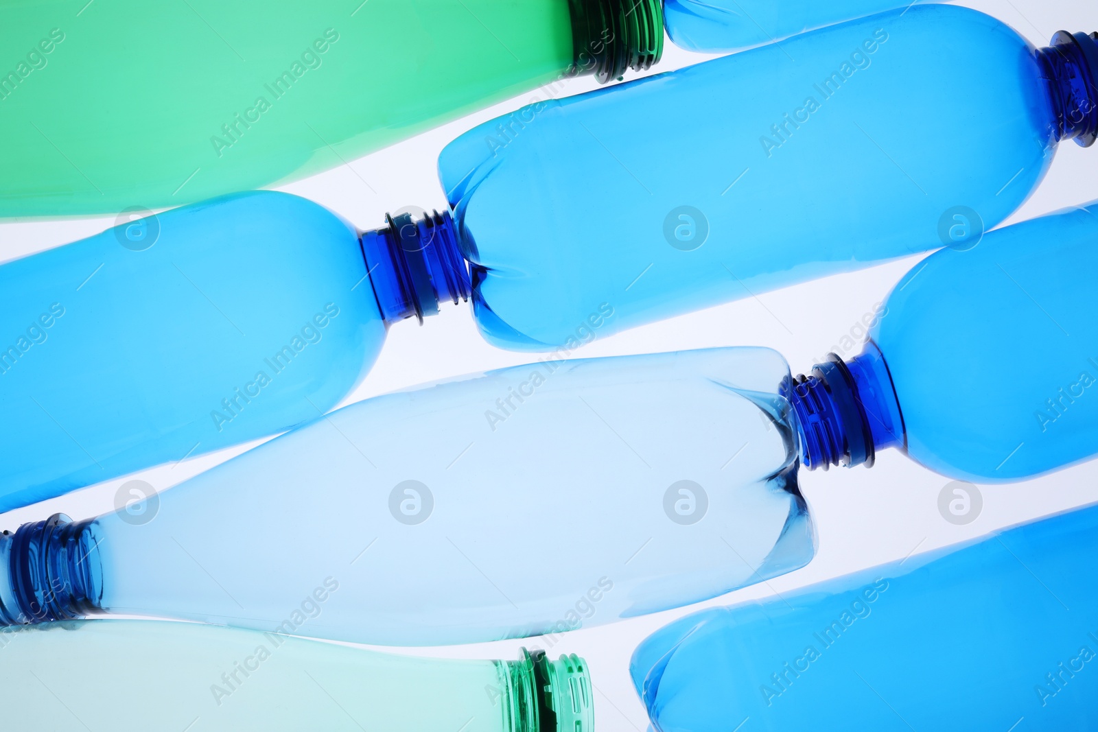 Photo of Empty plastic bottles on white background, top view