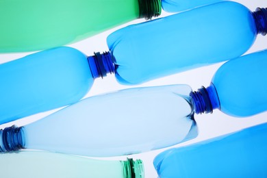 Photo of Empty plastic bottles on white background, top view