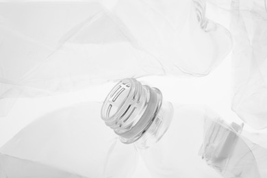 Photo of Crumpled plastic bottles on white background, closeup