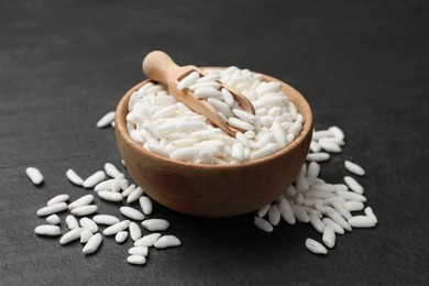 Photo of Puffed rice in bowl and scoop on dark table